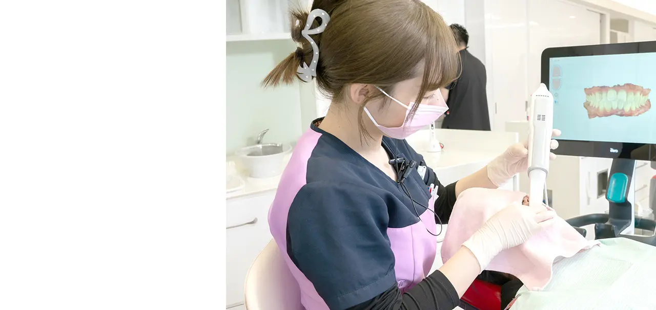 患者の口腔内をスキャンしている歯科衛生士