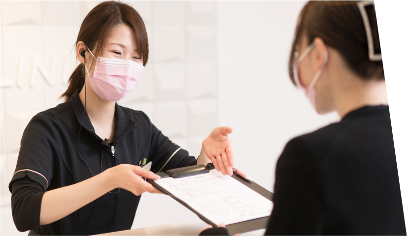 費用の説明をする受付スタッフ